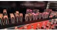 Cosmetic lipstick products and their packaging arranged on the shelf.