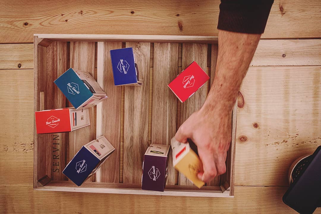 Top view of seven nuts custom food packaging boxes inside a wooden tray.