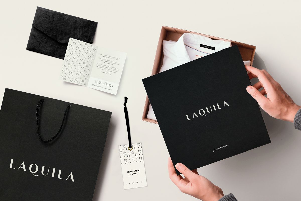 A box, a hang tag, an envelope, a flyer and a paper bag with a clothing packaging design applied.