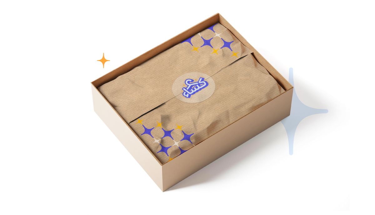 An opened box with brown wrapping paper inside it and a sticker with a clothing packaging design applied.