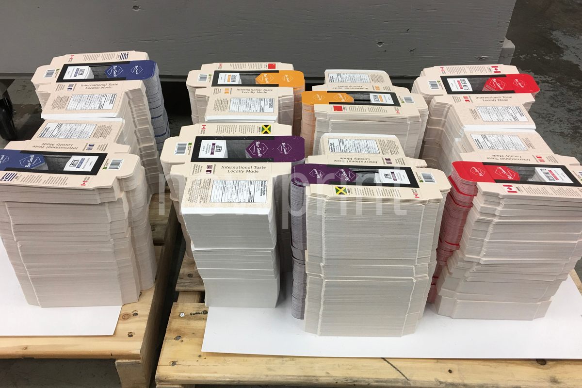 Guide to Custom Packaging-Eight stacks of printed and cut-to-shape product packaging boxes.