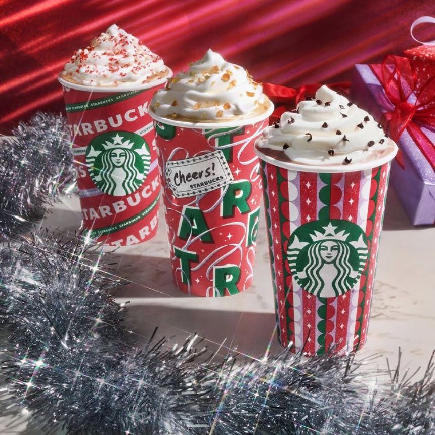 Three Starbucks coffee cups with holiday-themed design