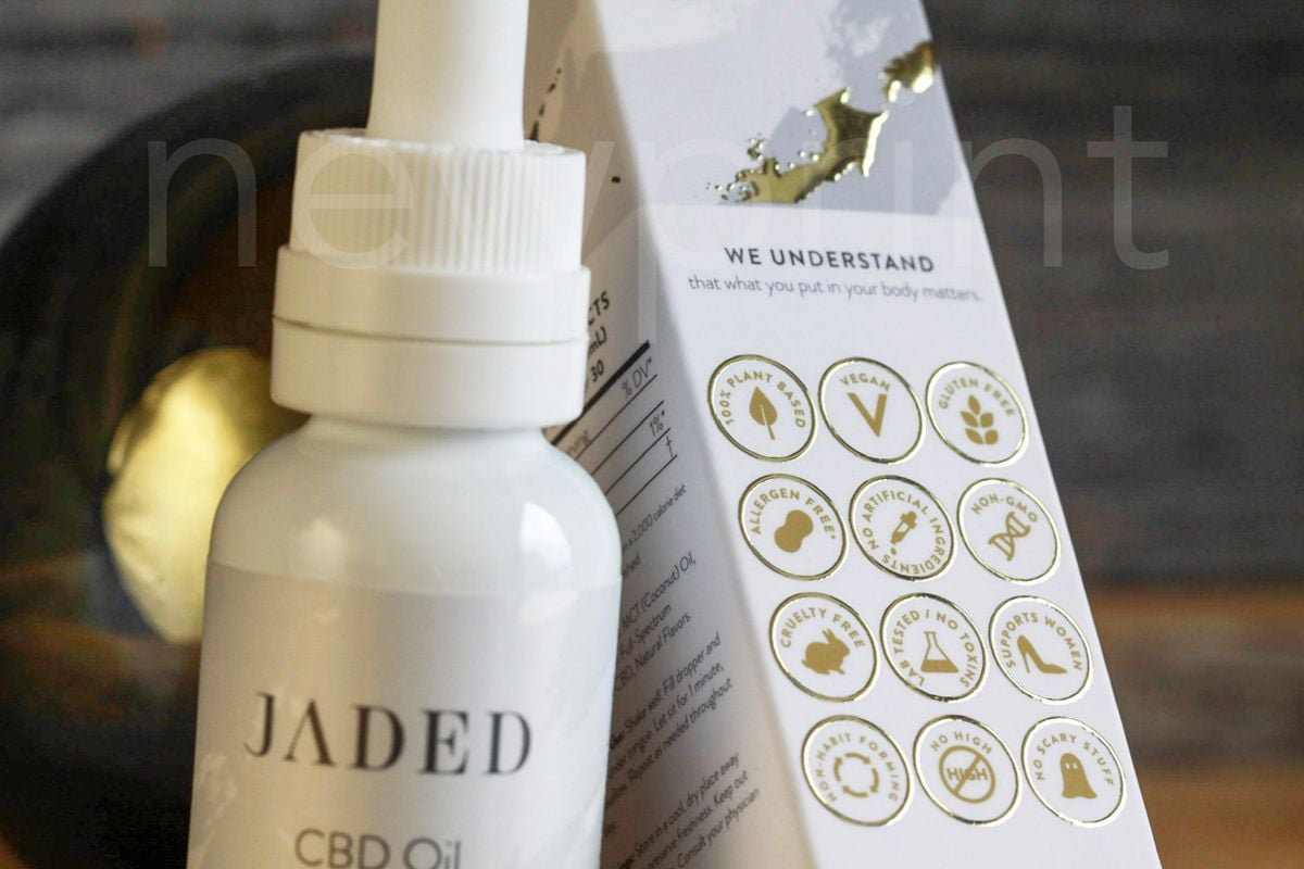 Close-up of a CBD oil bottle and its luxury packaging, showing gold foil and Pantone colour printing details.