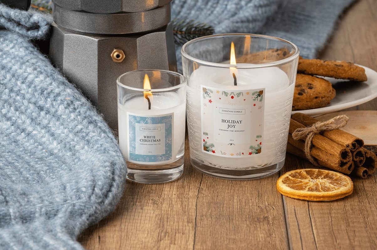 Christmas packaging design inspiration, two lit candles with Christmas-inspired labels.