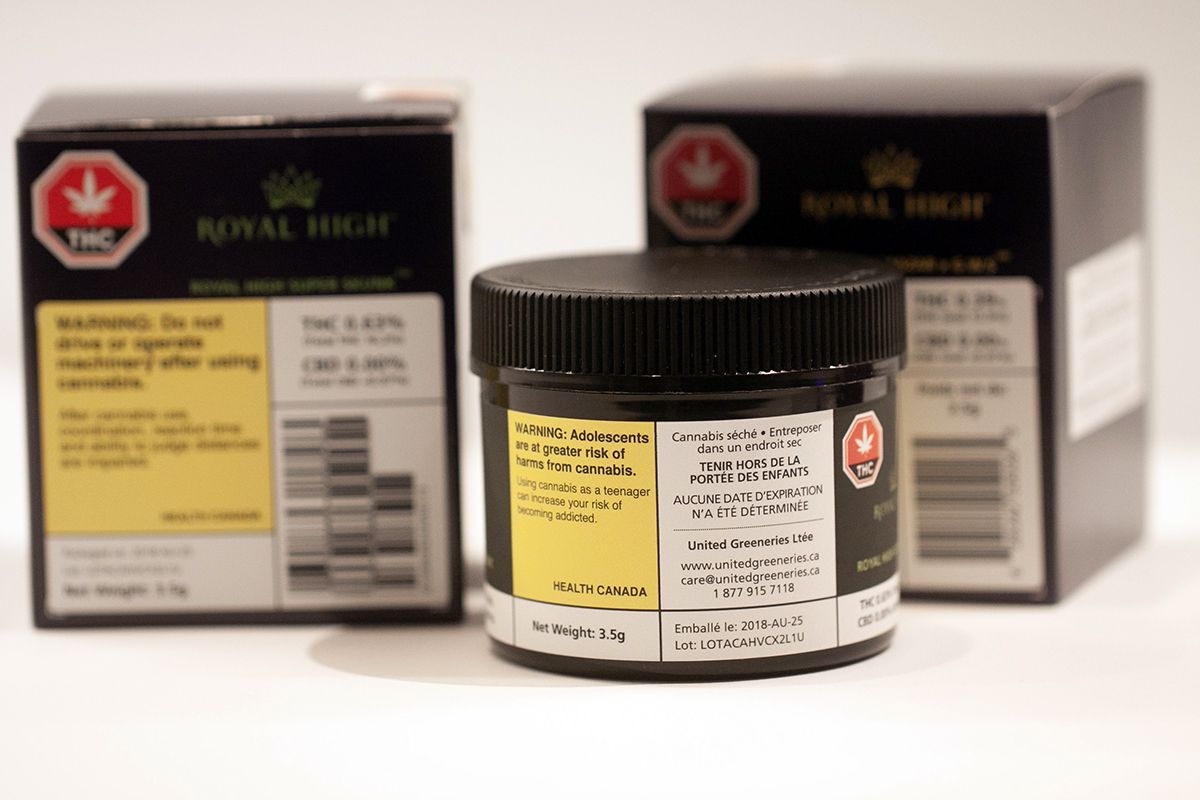 Two cannabis packaging boxes and a plastic jar with a custom label applied on the jar.