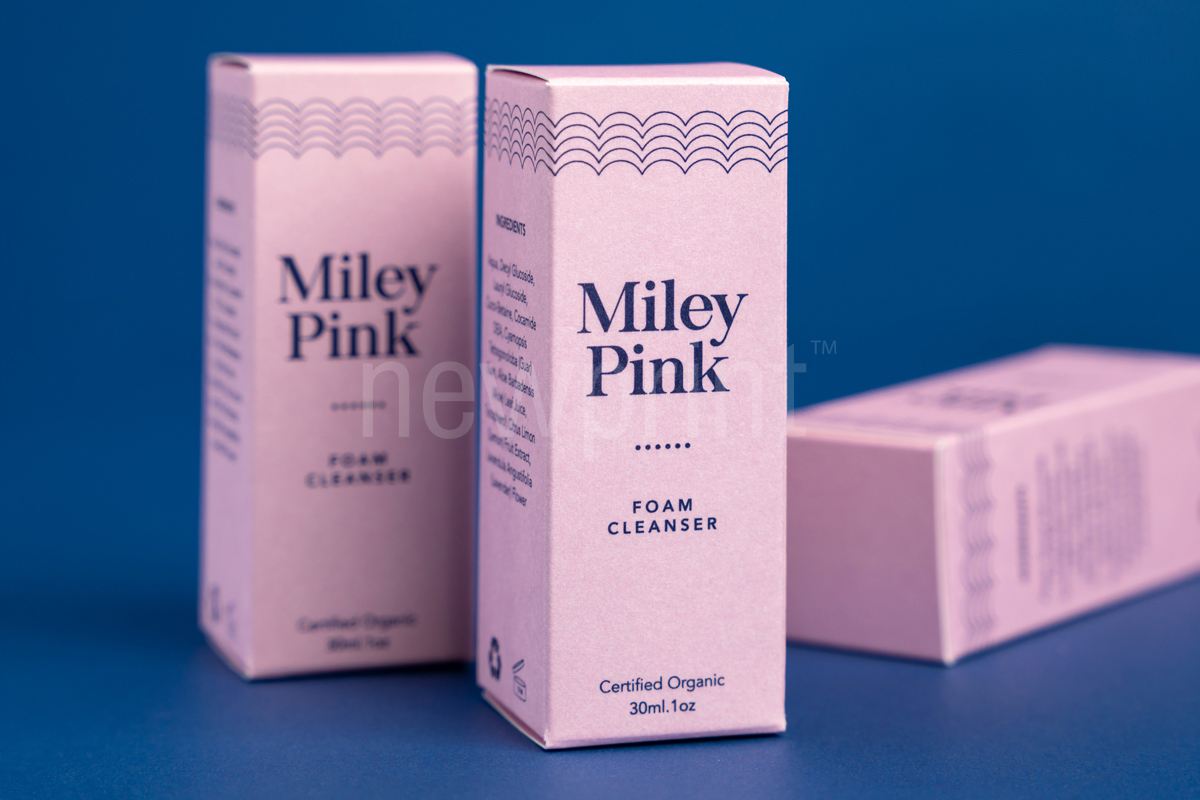 Three pink cosmetic packaging boxes on the blue background.