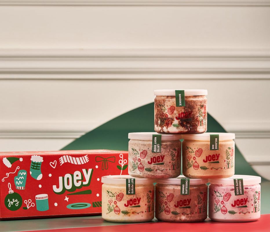 A holiday packaging box and six jars with holiday-themed labels.