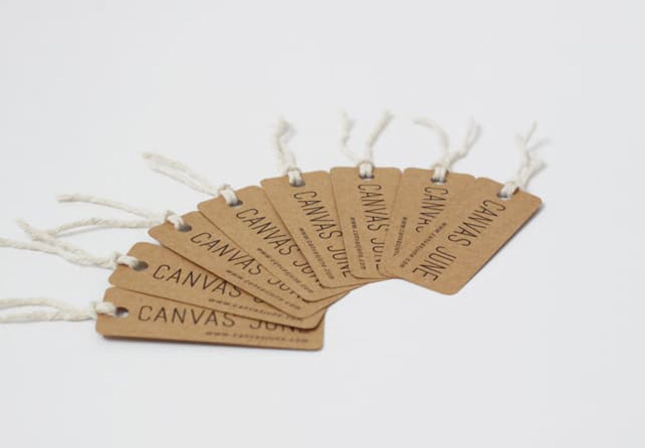 Simple hang tag examples on the white background, with just brand name on kraft paperboard.