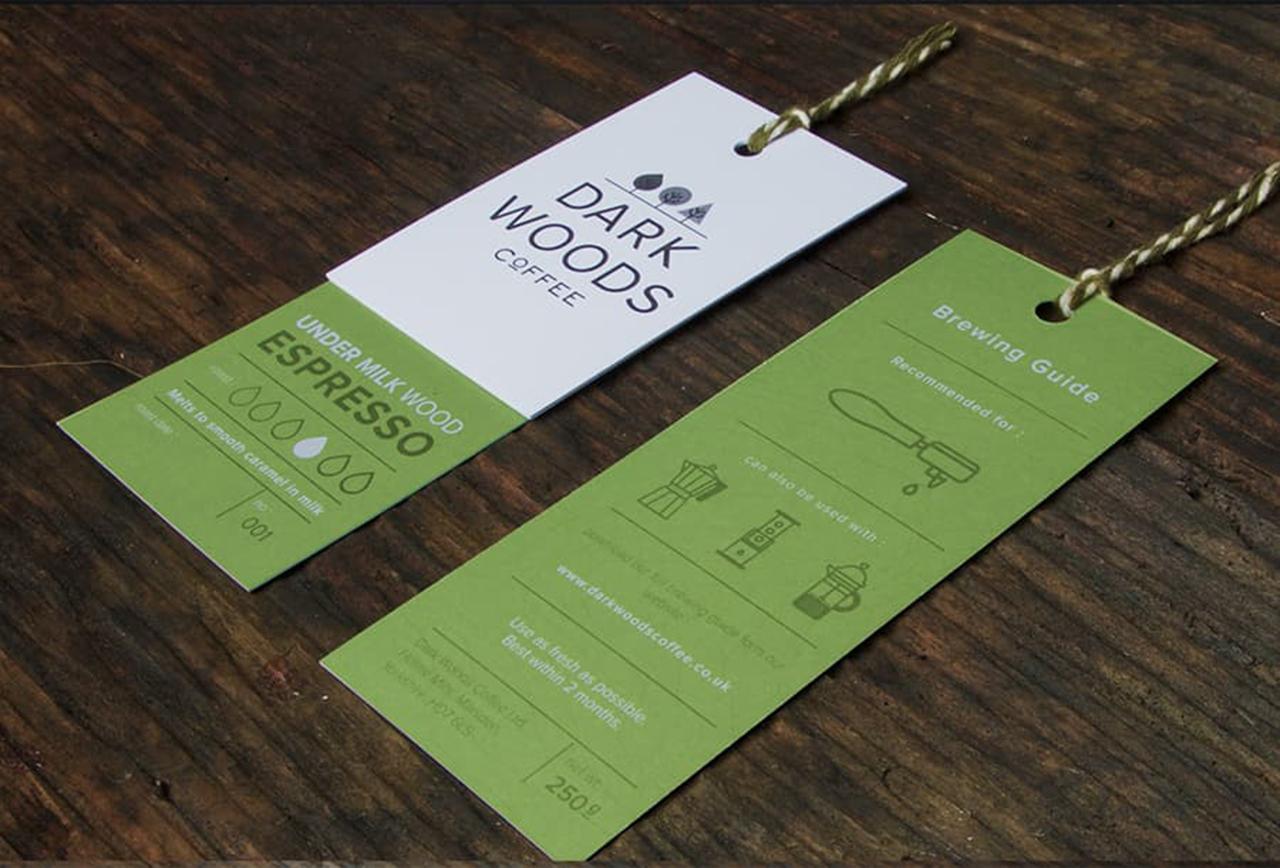One of the hang tag examples - simple green and white hang tag, front and back, on dark wood surface.