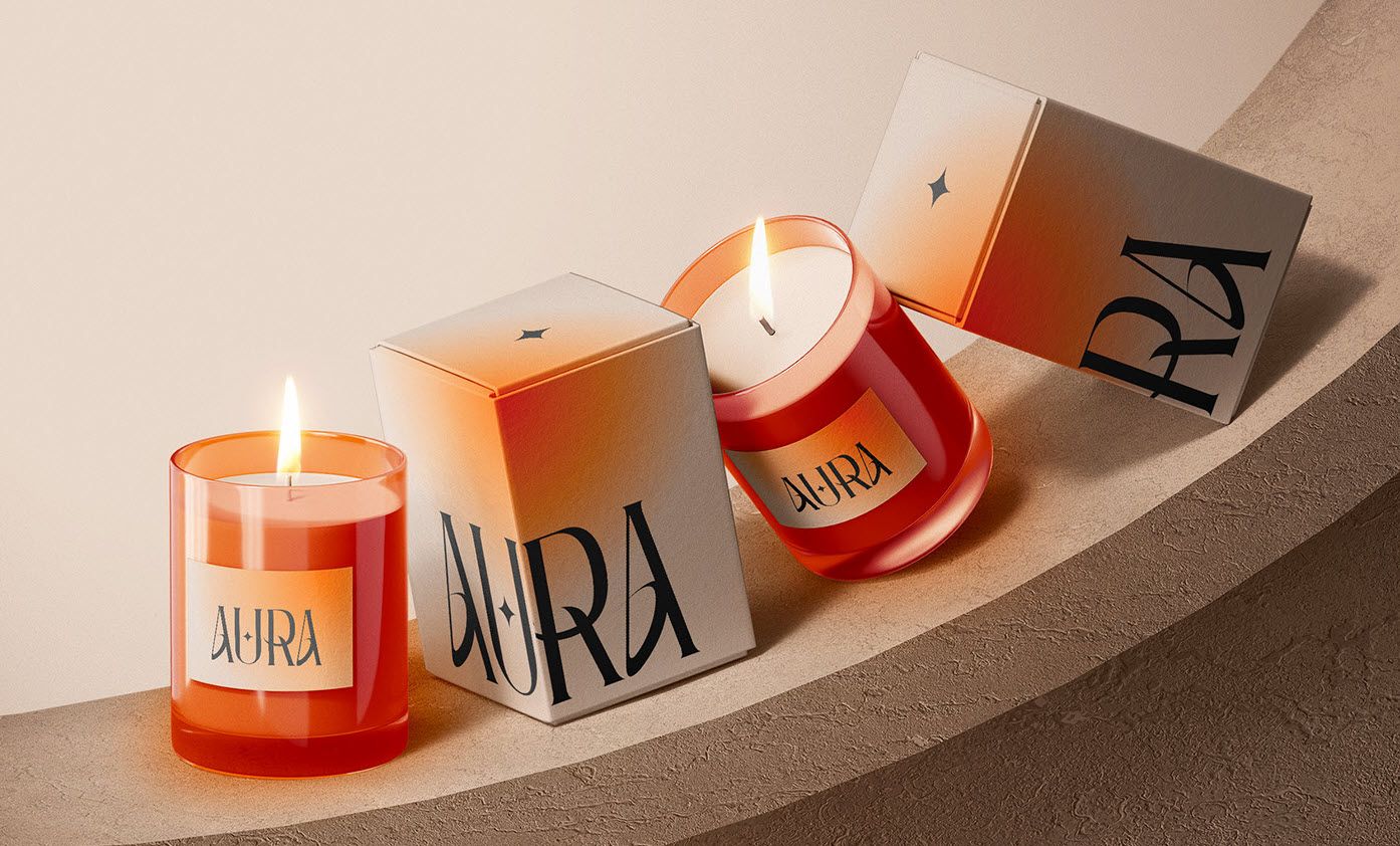 Two lighted candles with two paperboard candle boxes on a round wood surface.