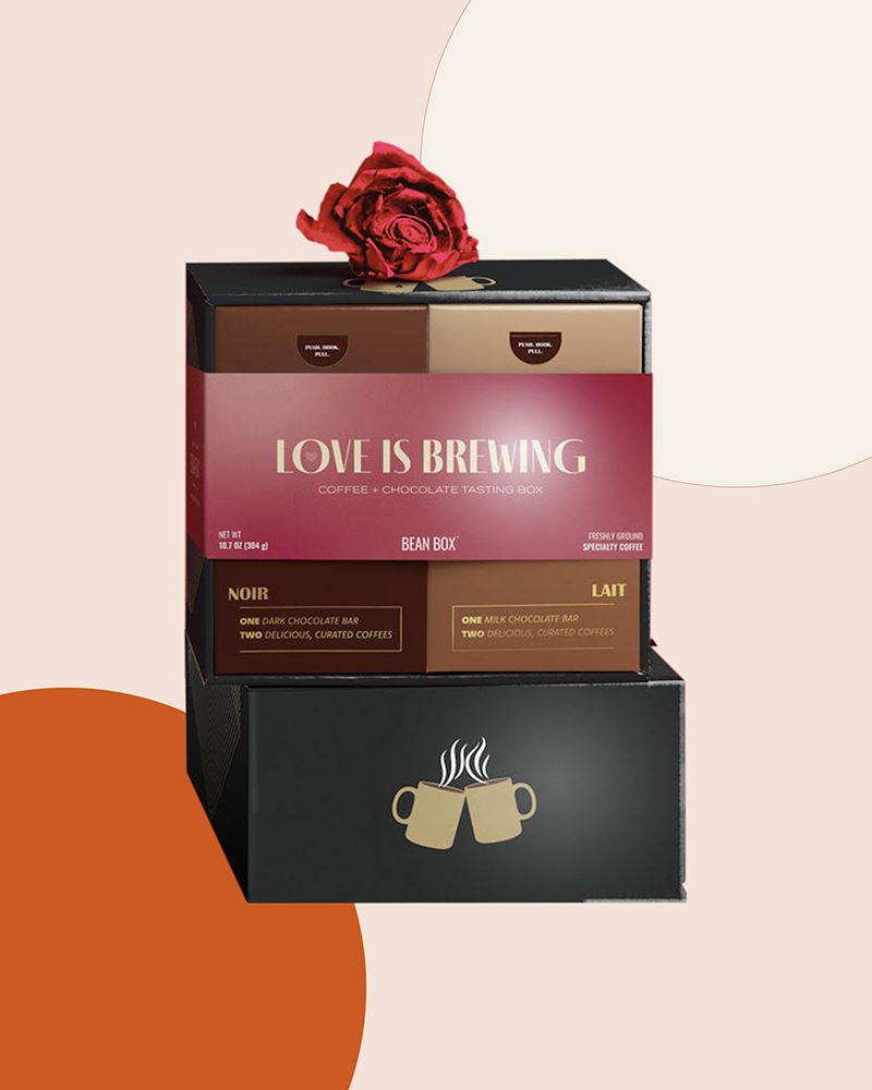 Valentine’s Day packaging for a tasting set of coffee and chocolates. Four smaller boxes in a larger box without a lid and with a packaging sleeve that has “love is brewing” written on it. And one large box under them, with two mugs on it.