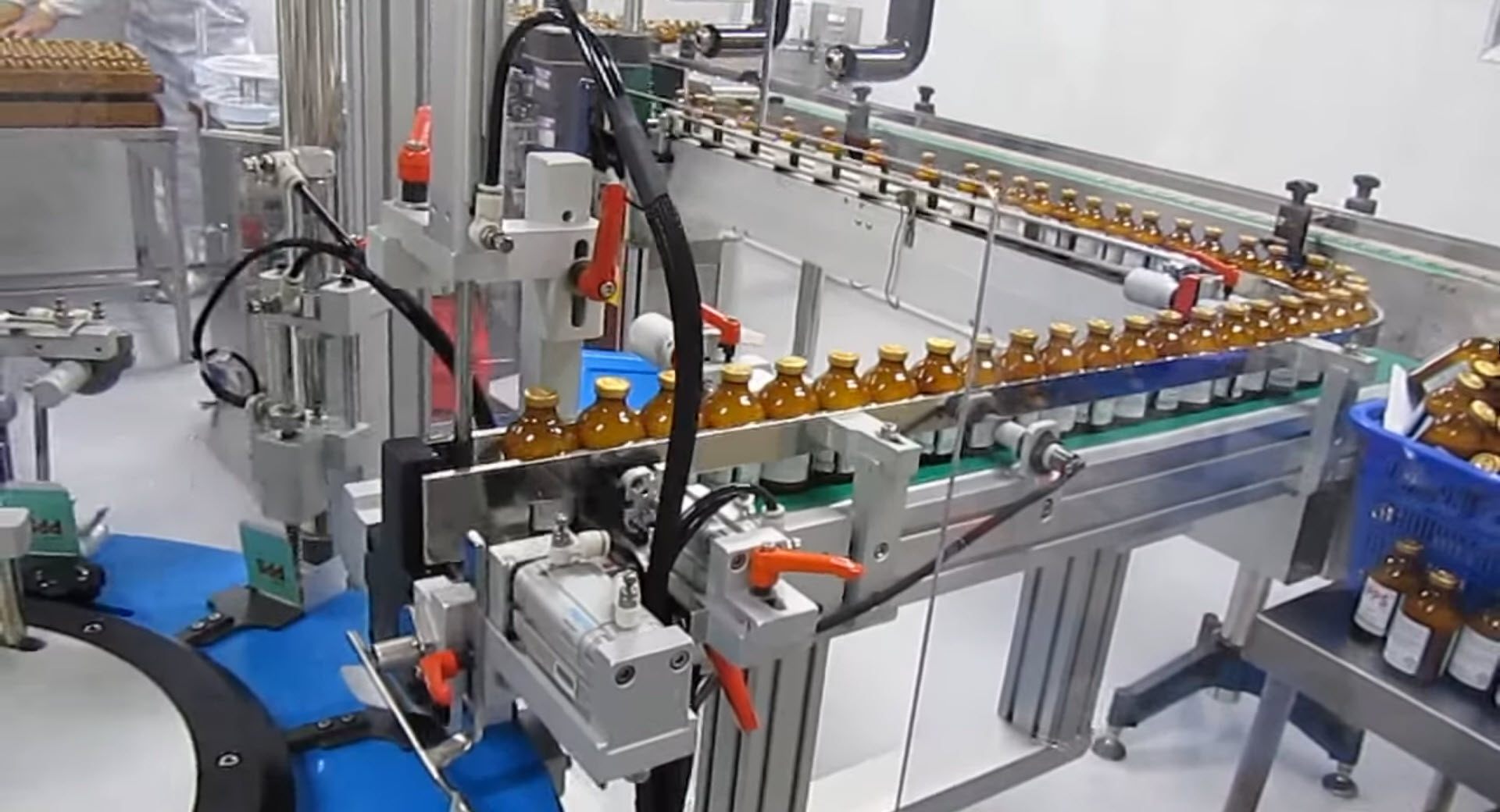 Glass bottle insertion into a packaging box on a high-speed robotic cartoning machine. 